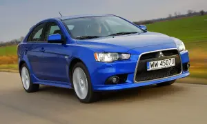 Niebieski Mitsubishi Lancer 9 w ruchu, z widocznym kierowcą i polskimi tablicami rejestracyjnymi.