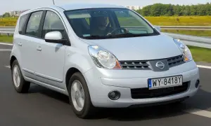 Srebrny Nissan Note na drodze. Kierowca w czapce prowadzi auto. Wiele osób szuka nissan note opinie przed zakupem.