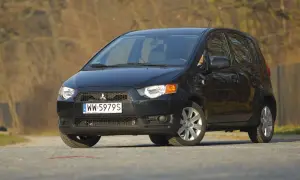 Czarny Mitsubishi Colt 1.3 na drodze, z widocznym numerem rejestracyjnym WW 5979S.