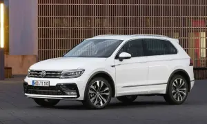 Biały Volkswagen Tiguan na tle nowoczesnej fasady. Wiele osób szuka **volkswagen tiguan opinie** przed zakupem.