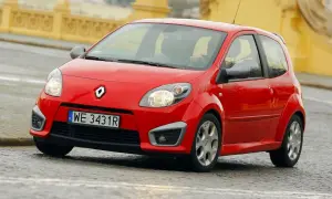 Czerwone Twingo RS na mokrej nawierzchni, z widocznym kierowcą za kierownicą.