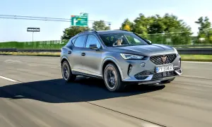 Srebrna karoseria sportowego SUV-a sunie po autostradzie.