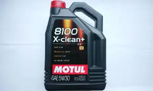 Czarna bańka oleju silnikowego Motul 8100 X-clean+ 5W30 z czerwonym korkiem.