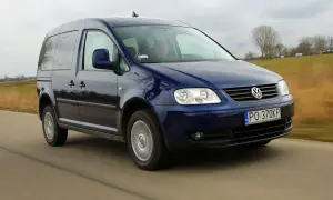 Ciemnoniebieski Volkswagen Caddy 3 w ruchu drogowym, z widocznym kierowcą.