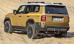 Złoty Land Cruiser z kolorowymi pasami na boku, gotowy na przygodę w piaskach pustyni, niczym potężna sequoia w krajobrazie.