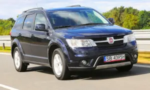 Ciemnoniebieski Fiat Freemont w ruchu drogowym. Wiele osób szuka fiat freemont opinie przed zakupem.