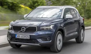 Ciemnogranatowy Volvo XC40 z białym dachem jedzie po drodze. Wiele osób szuka volvo xc40 opinie przed zakupem.