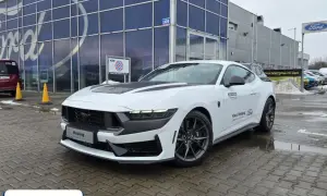 Biały Ford Mustang przed salonem Ford. Sprawdź aktualną mustang cena i dostępność od ręki.