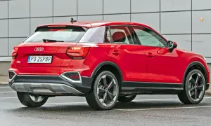 Czerwone Audi Q2 z polskimi tablicami PO 2SP89. Kompaktowy SUV, którego wymiary sprawiają, że jest idealny do miasta.