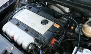 Silnik VR6-DOHC z widocznym filtrem powietrza i zbiorniczkiem płynu chłodniczego.