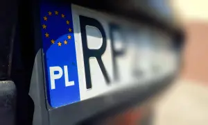Zbliżenie na polską tablicę rejestracyjną z symbolem Unii Europejskiej. Litery "PL" i fragment numeru rejestracyjnego są wyraźne.