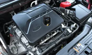 Silnik EcoBoost w Fordzie Escape 2020. Widoczna pokrywa silnika z logo Ford i napisem EcoBoost, akumulator i elementy układu dolotowego.