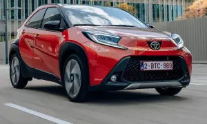 Czerwony Toyota Aygo w ruchu miejskim. Wiele osób szuka toyota aygo opinie, by poznać ten model.
