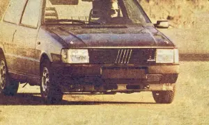 Ciemny Fiat Uno Turbo z kierowcą za kierownicą, gotowy do jazdy.