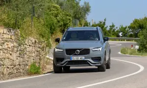 Szary Volvo XC90 2020 na krętej drodze wśród zieleni.