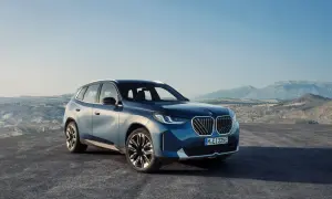 Nowy, błękitny BMW X3 2024 na tle górskiego krajobrazu.