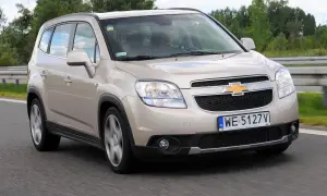 Złoty Chevrolet Orlando 1.8 benzyna na drodze. Rodzinny minivan w ruchu, z widocznym kierowcą.