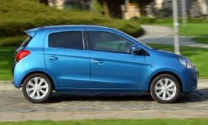 Niebieski Mitsubishi Space Star w ruchu. Wiele osób szuka Mitsubishi Space Star opinie, ten samochód miejski jest idealny do miasta.