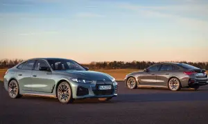 Dwa eleganckie BMW Gran Coupe, jedno zielone, drugie brązowe, stoją na asfalcie o zachodzie słońca.