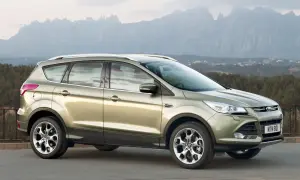 Złoty Ford Kuga na tle górskich krajobrazów. Wiele osób chwali ten model, a jego opinie są pozytywne.