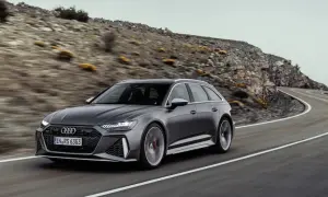 Szary Audi RS6 Avant pędzi po krętej drodze wśród skalistych wzgórz.
