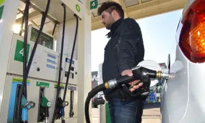 Mężczyzna tankuje benzynę do Skody Fabii 1.2. Dłoń trzyma pistolet paliwowy przy samochodzie.