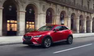 Czerwona Mazda CX-3 w ruchu miejskim. Wiele osób szuka mazda cx-3 opinie, by poznać ten stylowy crossover.