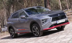 Szary Mitsubishi Eclipse Cross EV na leśnej drodze. Wiele pozytywnych mitsubishi eclipse cross opinie potwierdza jego wszechstronność.