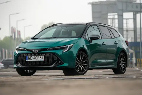 Zielona Toyota Corolla Touring Sports hybrid na mokrej nawierzchni.