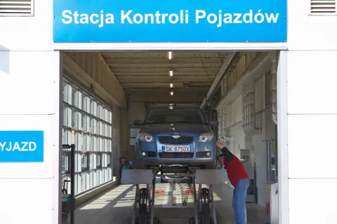 Pracownik sprawdza samochód na podnośniku. Dowiedz się, ile kosztuje przegląd samochodu w stacji kontroli pojazdów.