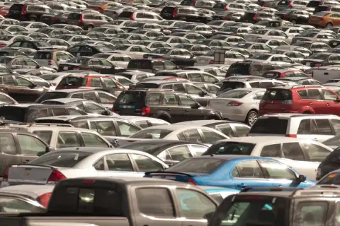 Ogromny parking pełen nowych sedanów i innych samochodów.