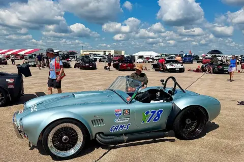 Błękitny Shelby Cobra z numerem 178 na torze wyścigowym, gotowy do startu.