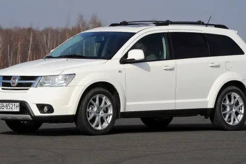 Biały fiat 7 osobowy z relingami na dachu, gotowy na rodzinną podróż.