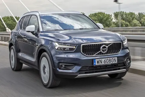 Ciemnoszary Volvo XC40 jedzie po moście. Sprawdź aktualną volvo xc40 cena i dostępne wersje.