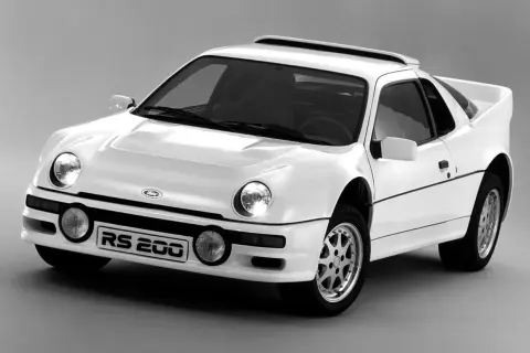 Biały Ford RS200, jeden z legendarnych modeli Forda, z charakterystycznym spojlerem i okrągłymi światłami.