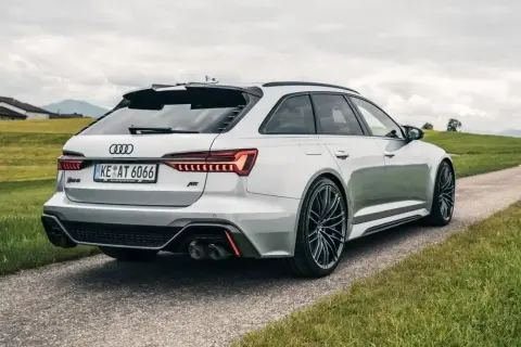 Srebrne Audi RS6 z pakietem ABT na tle zielonych wzgórz. Zastanawiasz się nad audi rs6 cena?