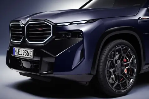 Elegancki, ciemnoniebieski BMW XM z podświetlaną atrapą chłodnicy i sportowymi felgami. Sprawdź BMW XM cena i możliwości tego SUV-a.
