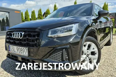 Czarny Audi Q2 na żwirowym podjeździe. Sprawdź atrakcyjną audi q2 cena i zarezerwuj jazdę próbną.