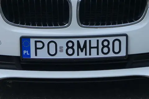 Biały samochód z tablicą rejestracyjną PO-8MH80.