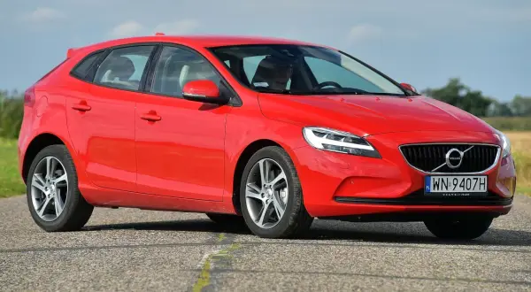 Czerwone Volvo V40 D3 na drodze, z widoczną sylwetką kierowcy.