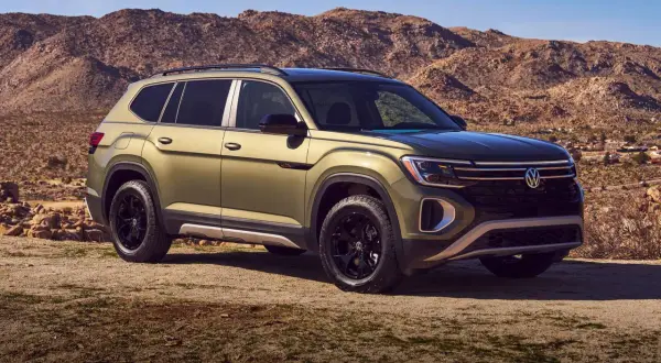 Zielony VW Atlas na tle pustynnego krajobrazu.