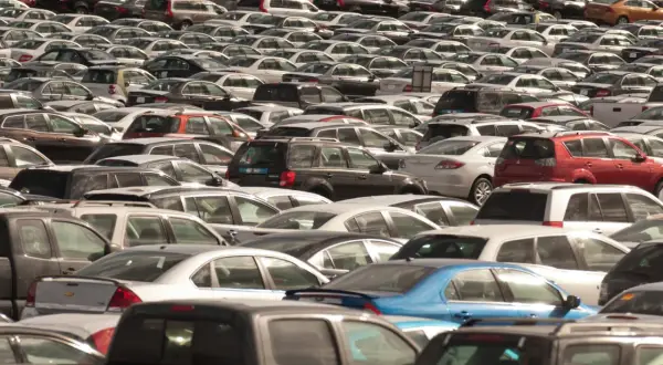 Ogromny parking pełen nowych sedanów i innych samochodów.