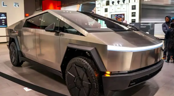 Futurystyczny Cybertruck Tesli błyszczy w salonie, gotowy na przygodę.