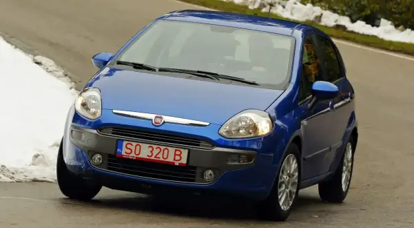 Niebieski Fiat Punto na drodze, z widoczną czerwoną rejestracją SO 320 B.
