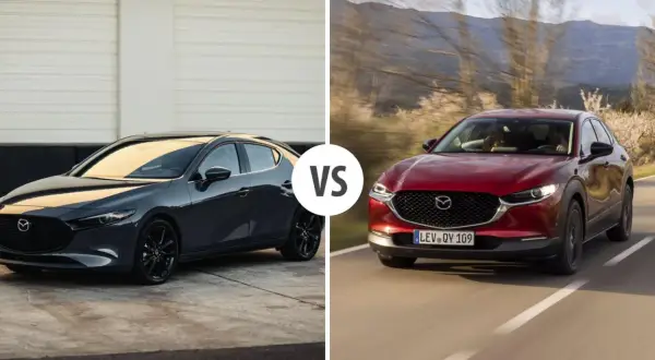 Szary Mazda 3 sedan obok czerwonego crossovera na drodze.