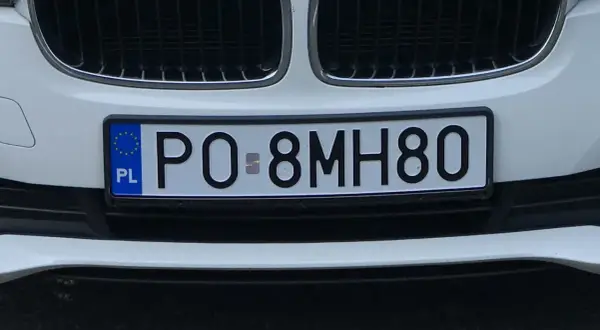 Biały samochód z tablicą rejestracyjną PO-8MH80.