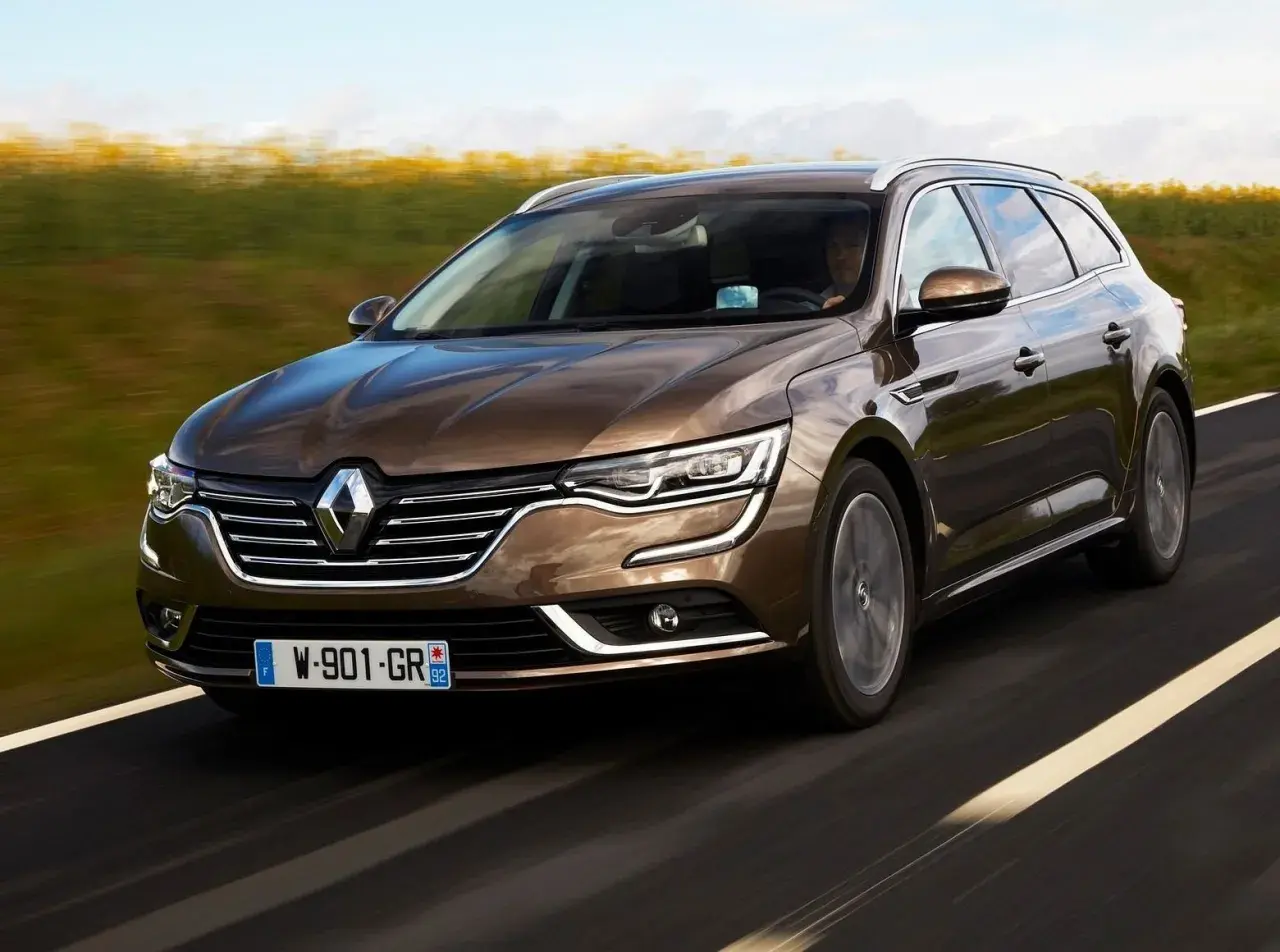Brązowe kombi Renault Talisman na drodze. Wiele osób szuka **Renault Talisman opinie** przed zakupem.