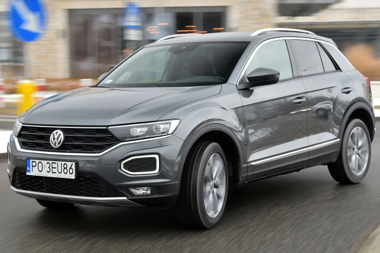 Szary Volkswagen T-Roc w ruchu miejskim. Wiele osób szuka volkswagen t-roc opinie, by podjąć decyzję o zakupie.