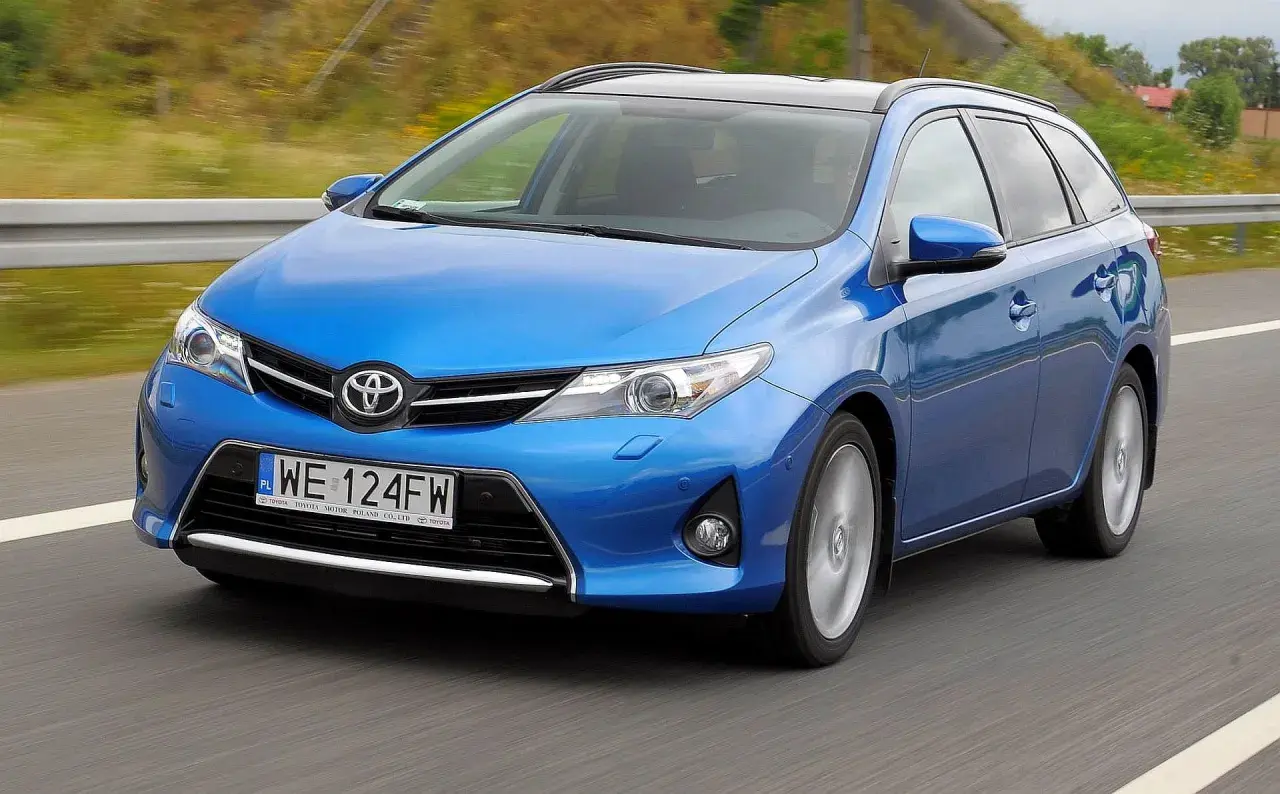 Niebieski Toyota Auris 2015 na drodze, z rozmytym tłem.