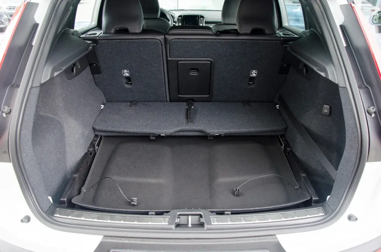 Pusta przestrzeń bagażowa Volvo XC60. Widoczne składane siedzenia i podłoga bagażnika, co pozwala ocenić jego wymiary.